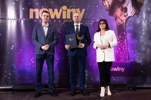 Odznaczony policjant z organizatorami plebiscytu. W tle, nazwa konkursu Osobowość Roku 2022 Nowiny 24.pl