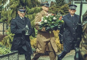 Delegacja przedstawicieli służb mundurowych podczas rocznicowych uroczystości. Skład delegacji stanowi strażak, żołnierz oraz policjant w umundurowaniu wyjściowym