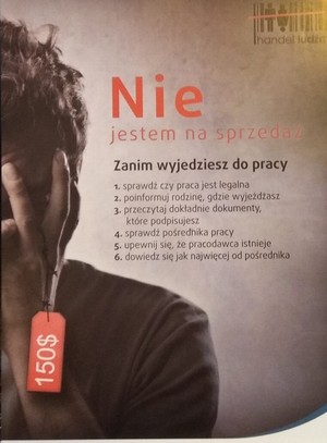 Plakat promujący kampanię przeciwko handlowi ludźmi przedstawiający osobę z zakrytą twarzą dłońmi i zawieszką cenową na palcu 150$. Obok treść „Nie jestem na sprzedaż” oraz poniżej wskazówki dotyczące weryfikacji pracodawcy opatrzone nagłówkiem „Zanim wyjedziesz do pracy”