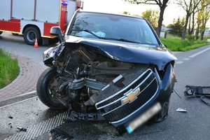 Uszkodzenia pokolizyjne przedniej części chevroleta uczestniczącego w zdarzeniu. W tle wóz strażacki