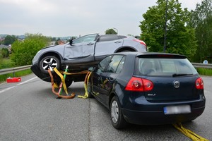 Uszkodzenia powypadkowe volkswagena i nissana. Nissan przechylony na bok, zabezpieczony specjalistycznymi podporami