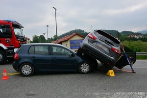 Uszkodzenia powypadkowe volkswagena i nissana. Nissan przechylony na bok, zabezpieczony specjalistycznymi podporami