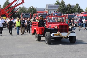 zabytkowy pojazd strażacki podczas festynu, w tle uczestnicy wydarzenia