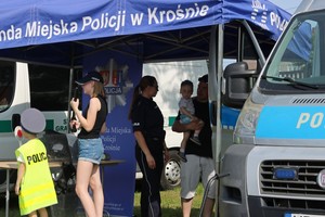 Policjanci podczas festyny podczas prezentacji wyposażenia na stoisku ekspozycyjnym