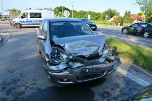 Uszkodzenia pokolizyjne przedniej części toyoty. W tle policyjny radiowóz