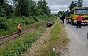 Znajdująca się w rejonie torowiska skoda. Obok przyglądający się zdarzeniu ludzie oraz samochód pomocy drogowej