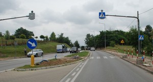 Zdjęcie przejścia dla pieszych, na którym doszło do potrącenia mężczyzny. W tle policyjny radiowóz, przejeżdżające samochody oraz elementy infrastruktury drogowej