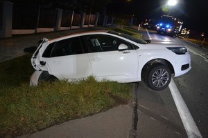 Uszkodzenia powypadkowe znajdującego się w przydrożnym rowie citroena. W tle pojazdy służb ratowniczych