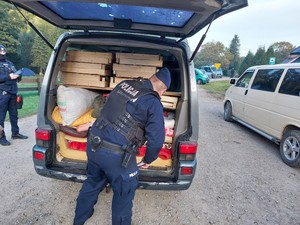 policjant kontrolujący bagażnik pojazdu