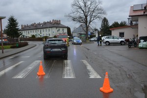 Miejsce wypadku drogowego w Jedliczu. Na pierwszym planie pachołki zabezpieczające, dalej przejście dla pieszych i uczestnicząca w zdarzeniu mazda. W tle pojazdy służb ratowniczych