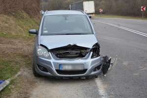 uszkodzenia przedniej części opla uczestniczącego w zdarzeniu drogowym. w tle naczepa samochodu ciężarowego