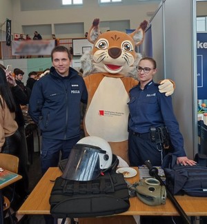 policjanci w towarzystwie maskotki na targach pracy w Krośnie