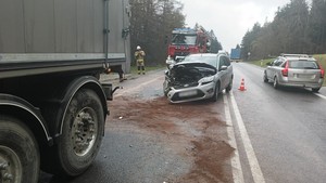 fragment naczepy pojazdu ciężarowego, w tle uszkodzona przednia część osobowego forda