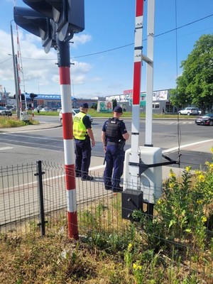 policjant i funkcjonariusz SOK podczas kontroli przejazdu drogowo-kolejowego