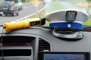 urządzenie do badania stanu trzeźwości kierujących i czapka policjanta ruchu drogowego we wnętrzu radiowozu