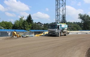 ciężarówka na torze żużlowym, obok uszkodzonej bandy