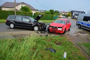 Uszkodzenia powypadkowe volkswagena i skody. W tle policyjny radiowóz