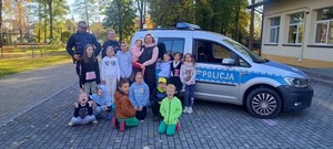 policjanci na tle radiowozu - wspólna fotografia z dziećmi