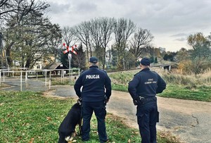 policjant z psem służbowym oraz funkcjonariusz Straży Ochrony Kolei podczas patrolu