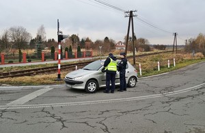 funkcjonariusz straży ochrony kolei oraz policjant podczas kontroli drogowej