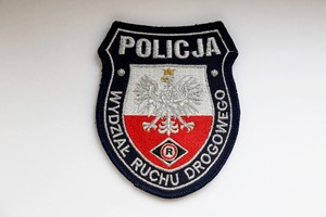 naszywka z logotypem wydziału ruchu drogowego, w jej górnej części napis Policja