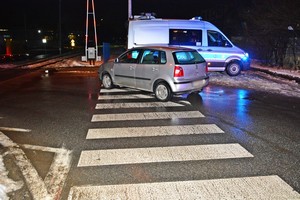 volkswagen stojący na przejściu dla pieszych, w tle policyjny radiowóz