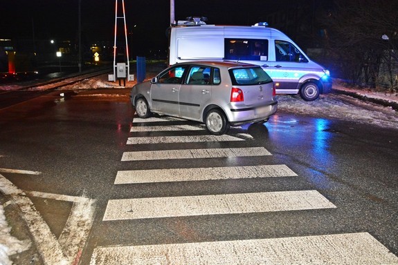 volkswagen stojący na przejściu dla pieszych, w tle policyjny radiowóz