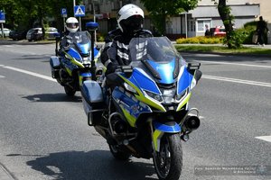 dwóch policjantów jadących ulica na motocyklach służbowych
