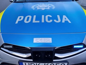 przednia część radiowozu z napisem policja na niebieskim tle pokrywy silnika