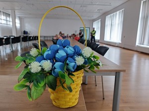 doniczka kwiatowa, w tle dzieci uczestniczące w spotkaniu