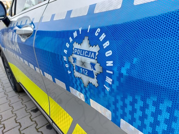 hasło pomagamy i chronimy na niebieskim tle pasa bocznego radiowozu