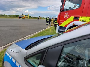 policyjny radiowóz, wóz strażacki, na drugim planie śmigłowiec LPR
