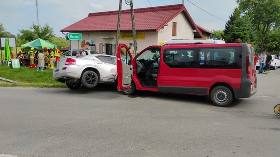 uszkodzenia powypadkowe pojazdów biorących udział w zdarzenia. W tle pracujący na miejscu strażacy i policjanci