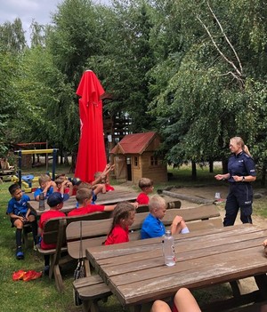 policjantka podczas spotkania z uczestnikami wakacyjnego wypoczynku