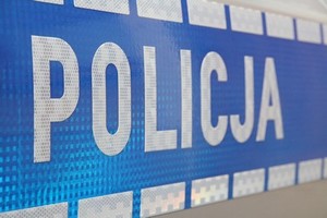 napis Policja na niebieskim tle drzwi radiowozu