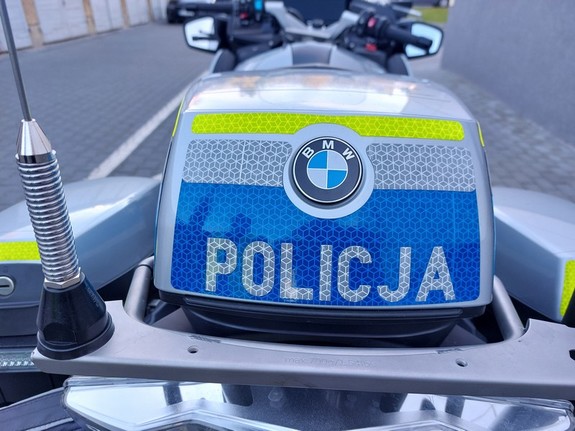 napis policja na niebieskim tle kufra motocykla służbowego