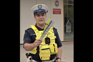 policjant ruchu drogowego trzyma w ręku odblaski