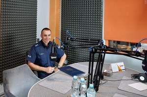 policjant podczas audycji w radiowym studiu