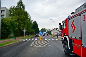 na pierwszym planie pojazd straży pożarnej, w tle radiowóz i pojazdy uczestniczące w zdarzeniu