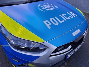 przednia część radiowozu z napisem policja na niebieskim tle pokrywy silnika