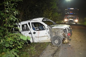 Uszkodzenia powypadkowe fiata. W tle samochód ratowniczy straży pożarnej