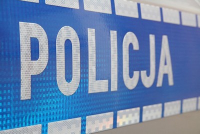 napis policja na niebieskim tle drzwi radiowozu