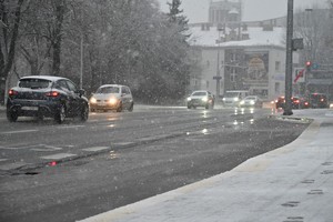 zaśnieżona miejska ulica oraz samochody