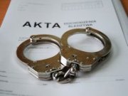 Kajdanki leżące na aktach sprawy